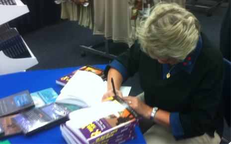Author Patricia Gerecht signs a copy of The Military Spouse, a practical guide to managing a military household