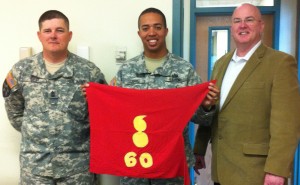 Mark Gerecht presents a guidon to the leadership team of 60th ORD at Fort Carson
